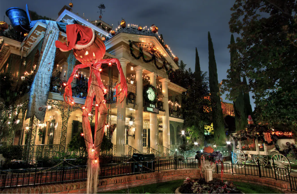 the haunted mansion decorated for the holidays