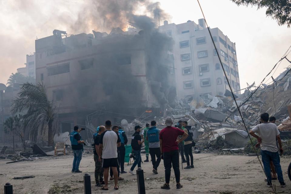 Palestinians inspect the rubble of a building in Gaza City after it was hit by an Israeli airstrike (AP)