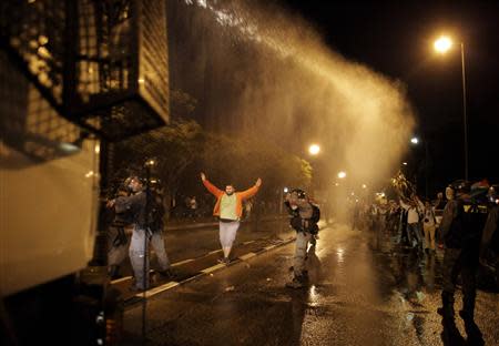 Israeli police use a water cannon to disperse Israeli Arab protesters during a demonstration showing solidarity with Bedouin Arabs who are against a government displacement plan for Bedouins in the Southern Negev desert in the northern city of Haifa November 30, 2013. REUTERS/Ammar Awad