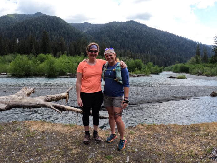 The Corcoran sisters pose for a photo in front of a stream.