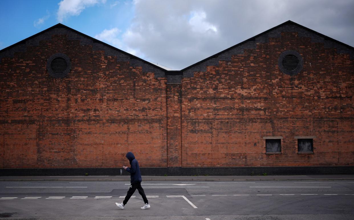 A man walks past the Alstom train manufacturing facility and factory