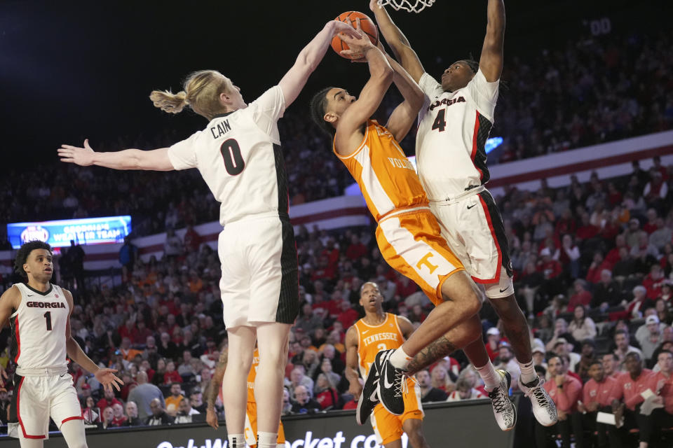 Tennessee guard Freddie Dilione V (1) goes up for a shot between Georgia's Blue Cain (0) and Silas Demary Jr. (4) during the half half of an NCAA college basketball game Saturday, Jan. 13, 2024, in Athens, Ga. (AP Photo/John Bazemore)