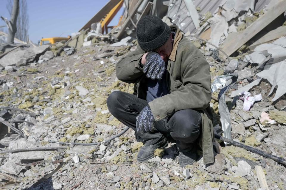 A man helping Ukrainian soldiers in the search pauses (AFP/Getty)