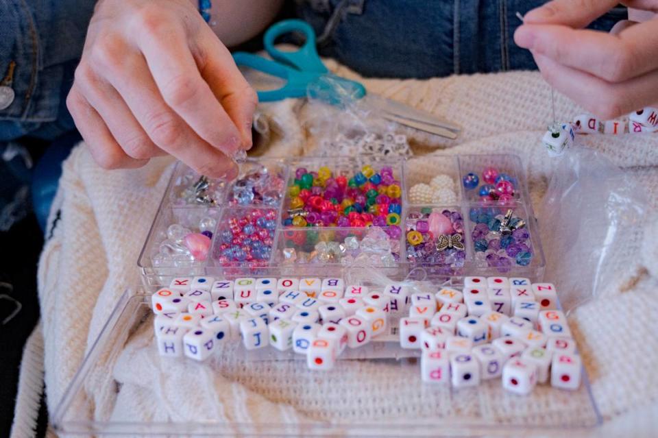 Annmargaret Dwyer creates friendship bracelets for Taylor Swift’s concert on Friday, July 28, 2023, during the three-hour train trip from Sacramento to Levi’s Stadium.