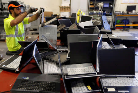 FILE PHOTO: A worker at the Ecomicro recycling company dismantles computers in Saint-Loubes near Bordeaux, France October 16, 2017. REUTERS/Regis Duvignau/File Photo