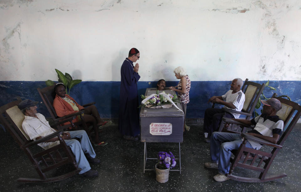 In this Feb. 5, 2014 photo, Divaldo Aguiar, who plays the part of Pachencho, lies inside a mock coffin during Burial of Pachencho celebration at a cemetery in Santiago de Las Vegas, Cuba. Cuban villagers stage a mock funeral and burial of Pachencho, with a living man playing the part of Pachencho, in a boozy festival that has become an annual tradition in this small town near Havana, held each Feb. 5 for the last 30 years. (AP Photo/Franklin Reyes)