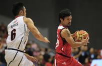 Manny Pacquiao, the playing coach of KIA-Sorento, is guarded by Alex Nuyles of Blackwater-Elite during the first quarter game of the 40th Season of the Philippine Basketball Association (PBA) games in Bocaue town, Bulacan province, north of Manila October 19, 2014. Pacquiao, a congressman and a world renowned boxing champion, ventured into the PBA as a playing coach on Sunday. Manny Pacquiao is scheduled for a title bout against Chris Algieri of the U.S. in Macau on November 22. REUTERS/Romeo Ranoco (PHILIPPINES - Tags: POLITICS SPORT BOXING BASKETBALL)