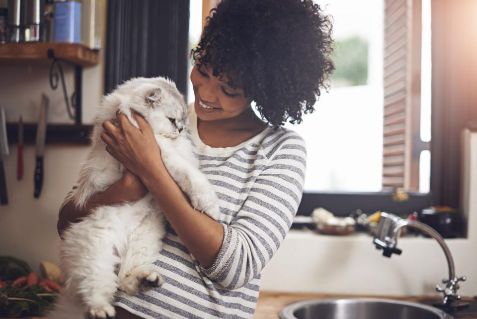 woman smiling and holding cat