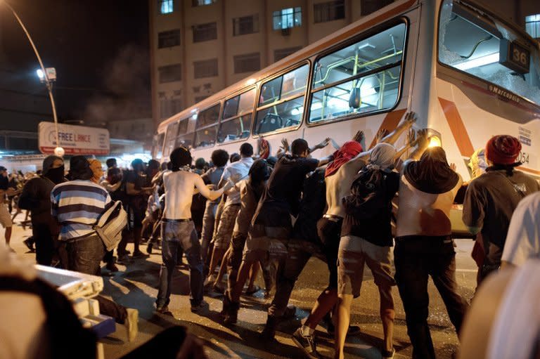 Demonstrators try to overturn a bus late on June 19, 2013 in the center of Niteroi, 10 kms from Rio de Janeiro. Pro