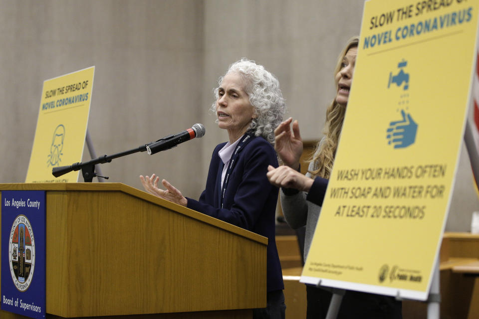 FILE - In this Thursday, March 12, 2020 file photo, Los Angeles County Public Health Director Barbara Ferrer, left, takes questions at a news conference in Los Angeles. On Friday, May 22, 2020, The Associated Press reported on a manipulated photo circulating online altered to show Ferrer looking unwell. In the manipulated May 13 image, her eyes were darkened to make it appear she had dark circles and her face was made pale. (AP Photo/Damian Dovarganes)