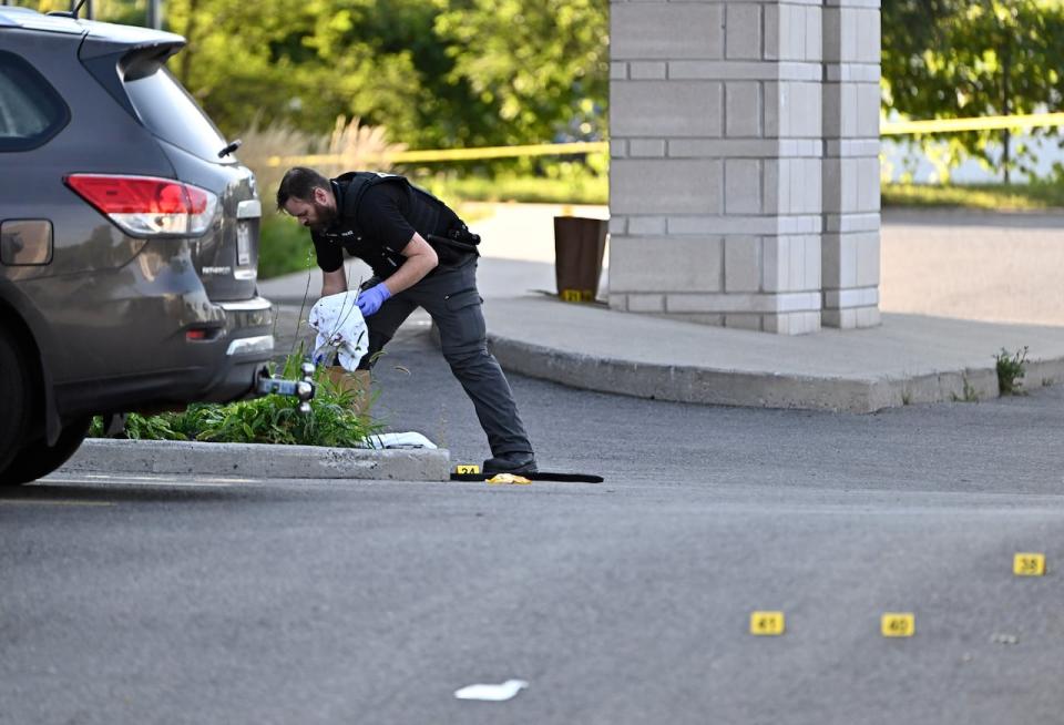 An Ottawa Police officer collects evidence after a Saturday night shooting at the Infinity Convention Centre that left two dead, in Ottawa, on Sunday, Sept. 3, 2023. 