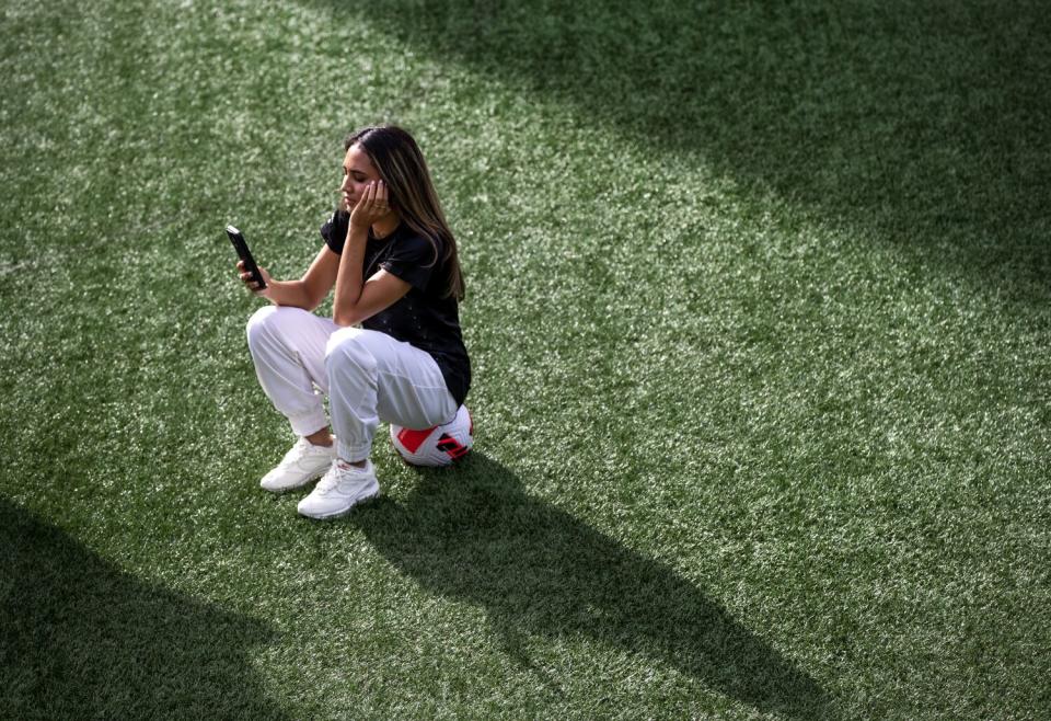 PLAYA VISTA, CA - JANUARY 12, 2023: Alyssa Thompson, 18, looks at photographs on a cell phone during a photo shoot.