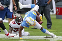 Tampa Bay Buccaneers free safety Jordan Whitehead (33) trips up Los Angeles Chargers running back Joshua Kelley (27) after a run during the first half of an NFL football game Sunday, Oct. 4, 2020, in Tampa, Fla. (AP Photo/Mark LoMoglio)