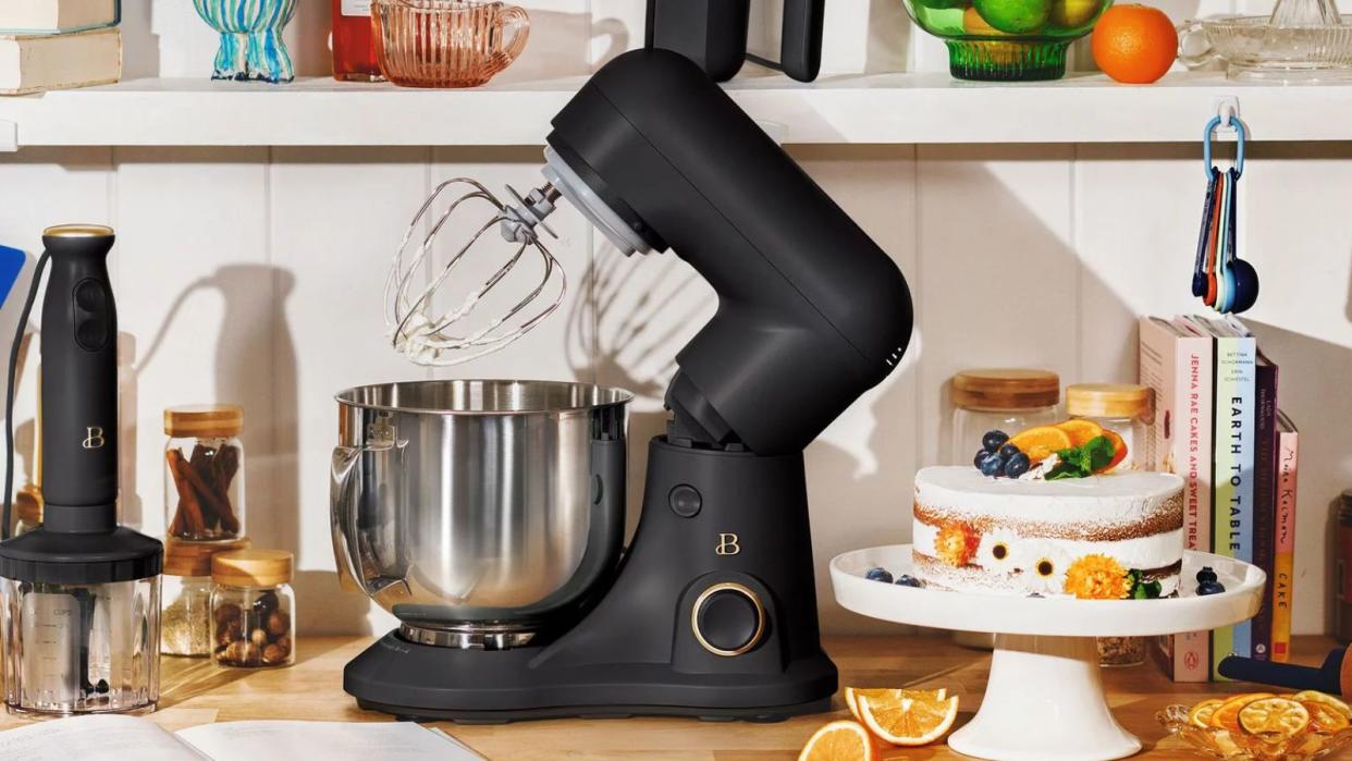  A Beautiful by Drew Barrymore Stand Mixer in a kitchen next to a cake . 