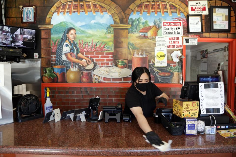 Maricela Moreno wipes down a counter at El Tarasco. She laughs a bit at her money laundering (the literal and legal kind, that is) but adds: "Why not? Just to be safe."