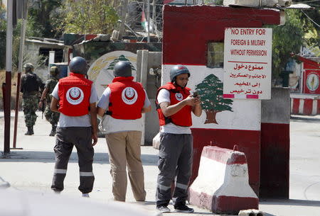 Members of the Islamic Medical Association stand at an entrance of Ain al-Hilweh Palestinian refugee camp during clashes between Palestinian Fatah gunmen and militants of Islamist group Jund al-Sham in the area, near the port-city of Sidon, southern Lebanon August 23, 2015. REUTERS/Ali Hashisho