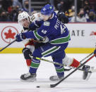 Florida Panthers' Anton Lundell (15) checks Vancouver Canucks' Elias Pettersson (40) during the third period of an NHL hockey game Friday, Jan. 21, 2022, in Vancouver, British Columbia. (Darryl Dyck/The Canadian Press via AP)