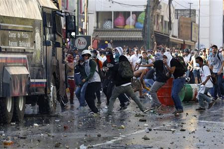 Opposition demonstrators throw stones against riot police during a protest against President Nicolas Maduro's government in Caracas February 15, 2014. REUTERS/Carlos Garcia Rawlins