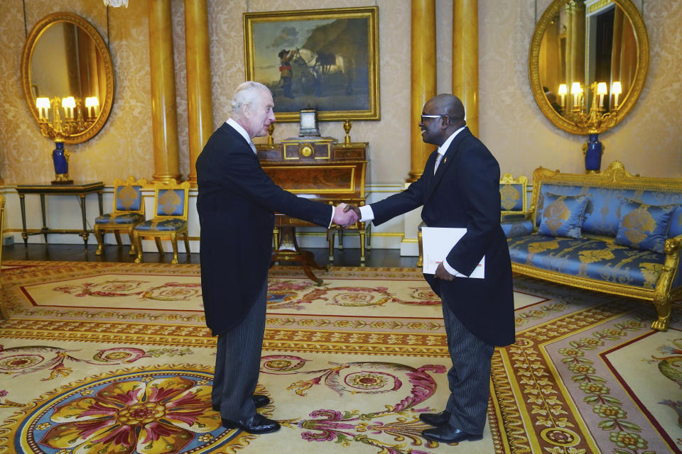 Ambassador of Burundi, Epimeni Bapfinda presents his credentials to Britain's King Charles III, left, during a private audience at Buckingham Palace, London, Thursday March 28, 2024. (Victoria Jones/Pool Photo via AP)