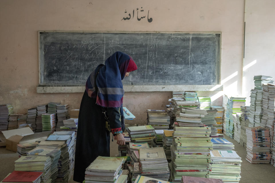 Amanah Nashenas, 45-year-old an Afghan teacher, collects books in a school in Kabul, Afghanistan, Thursday, Dec. 22, 2022. The country's Taliban rulers earlier this week ordered women nationwide to stop attending private and public universities effective immediately and until further notice. They have banned girls from middle school and high school, barred women from most fields of employment and ordered them to wear head-to-toe clothing in public. Women are also banned from parks and gyms.(AP Photo/Ebrahim Noroozi)