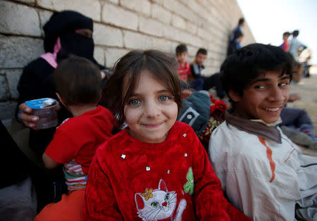 An Iraqi girl smiles after escaping from the Islamic State-controlled village of Abu Jarboa, Iraq October 31, 2016. REUTERS/Azad Lashkari