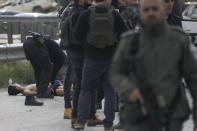 Israeli security forces examine the body of a Palestinian attacker outside the Israeli settlement of Maale Adumim, in the West Bank, Monday, Feb. 5, 2024. (AP Photo/Mahmoud Illean)