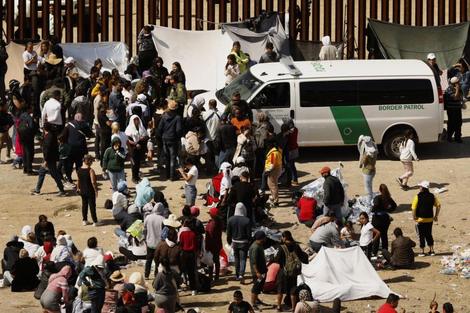 U.S. border patrol agents speak to migrants hoping to cross into the United States from Tijuana, Mexico