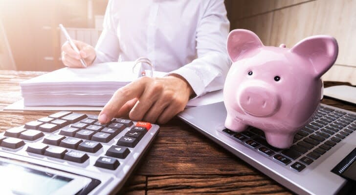 Man checking his 401(k) account with a piggybank on the desk