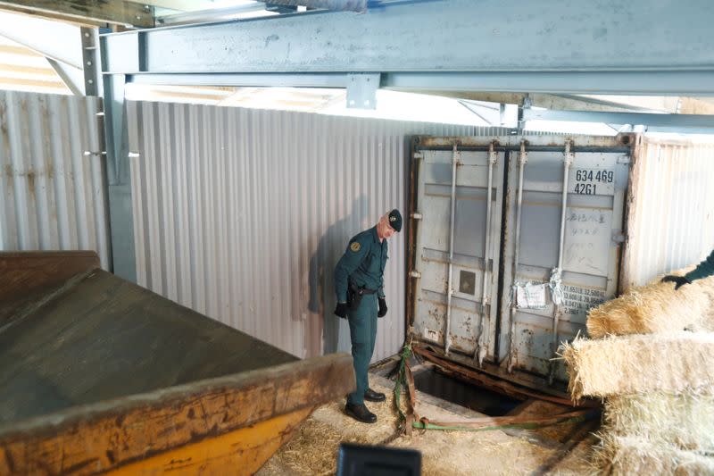 Un Guardia Civil se encuentra a la entrada de una fábrica subterránea ilegal de tabaco durante una redada policial en Monda, en el sur de España