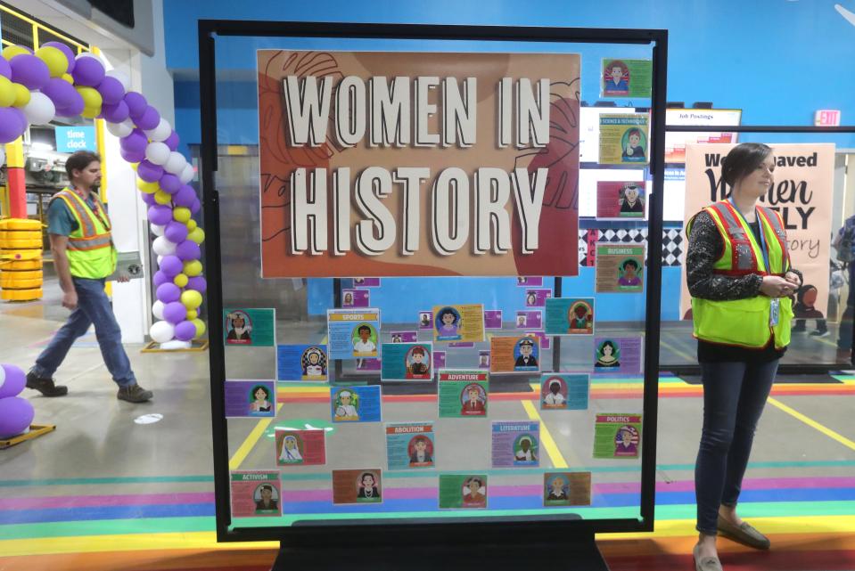 Akron Amazon Fulfillment Center employees pass a Women in History display in the entrance to the facility.