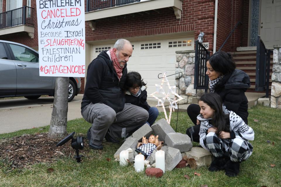 In front of their home Adam Shapiro, his son Diyaar Arraf-Shapiro, daughter Mayaar Arraf-Shapiro and wife Huwaida Arraf stand next to their nativity scene where Baby Jesus is in the middle of rubble from a collapsed building, declaring the Christmas is canceled just like it is in Bethlehem, because of the war in Gaza and the killing of Palestinian children.