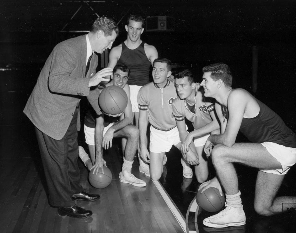 FILE - North Carolina basketball coach Frank McGuire, left, gives his five starting players some pointers during a workout at Municipal Auditorium in Kansas City, Mo., in March 1957. From left are McGuire, Lennie Rosenbluth, Tom Kearns, Bob Cunningham, Pete Brennan, and Joe Quigg. Rosenbluth, who led North Carolina to its first basketball NCAA title in 1957 with a victory over Wilt Chamberlain and Kansas in the championship game, died Saturday, June 18, 2022. He was 89. (AP Photo/William P. Straeter, File)