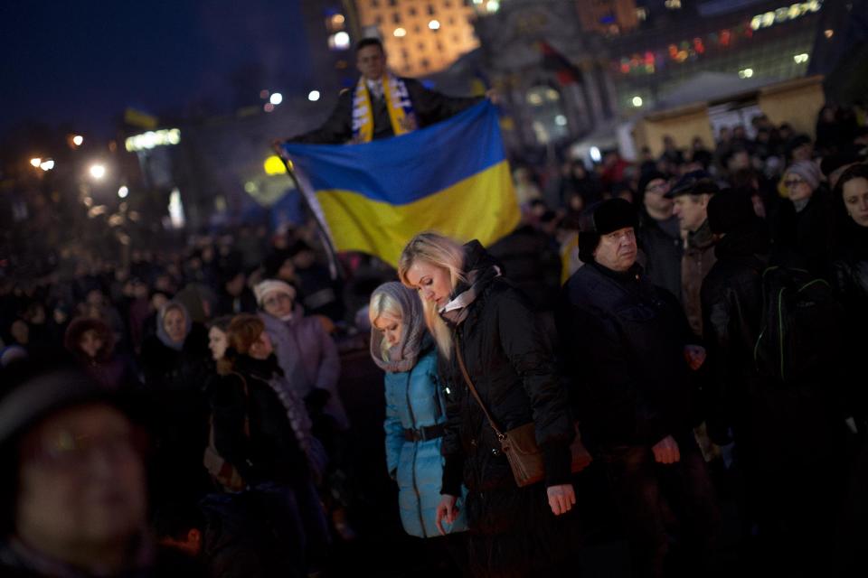 People walk at a memorial for the people killed in clashes with the police at the Independence Square, the epicenter of the country's current unrest, in Kiev, Ukraine, Wednesday, Feb. 26, 2014. Ukraine has been consumed by a three-month-long political crisis. President Viktor Yanukovych and protest leaders signed an agreement last week to end the conflict that left more than 80 people dead in just a few days in Kiev. Shortly after, Yanukovych fled the capital for his power base in eastern Ukraine but his exact whereabouts are unknown. (AP Photo/Emilio Morenatti)