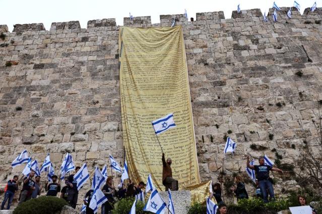 Demonstrators hang flags on the walls of Jerusalem's Old City in an act of protest as Israelis launch "Day of Shutdown” against judicial overhaul