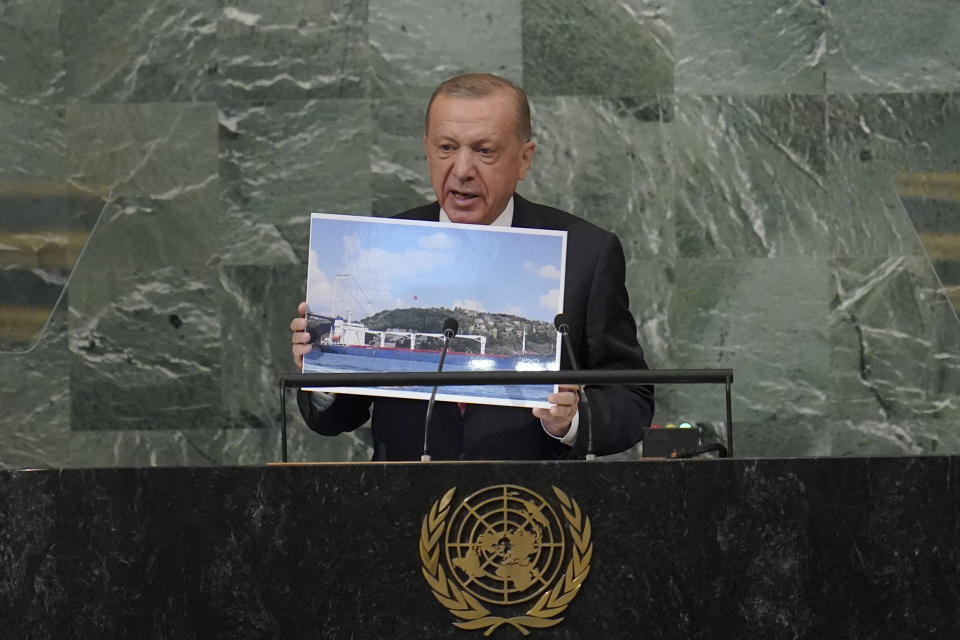 President of Turkey Recep Tayyip Erdogan holds up a photo of a Ukrainian grain ship as he addresses the 77th session of the United Nations General Assembly, Tuesday, Sept. 20, 2022 at U.N. headquarters. (AP Photo/Mary Altaffer)