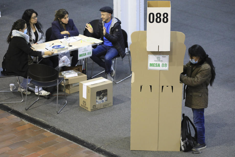 A woman chooses her candidate during a runoff presidential election in Bogota, Colombia, Sunday, June 19, 2022. (AP Photo/Jaime Saldarriaga)