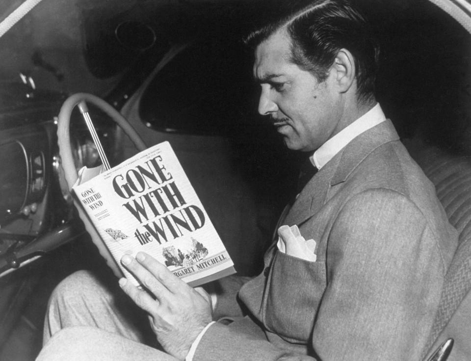 Clarke Gable reads Gone With the Wind in the driver's seat of a car