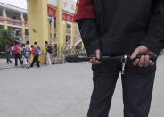 A security guard equipped with police baton stands at the entrance of a primary school in Hefei, Anhui province May 14, 2010. A spate of school killings in China has "deep-seated" roots in the country's social tensions which need addressing, Premier Wen Jiabao said. REUTERS/Stringer (CHINA - Tags: SOCIETY EDUCATION CRIME LAW)