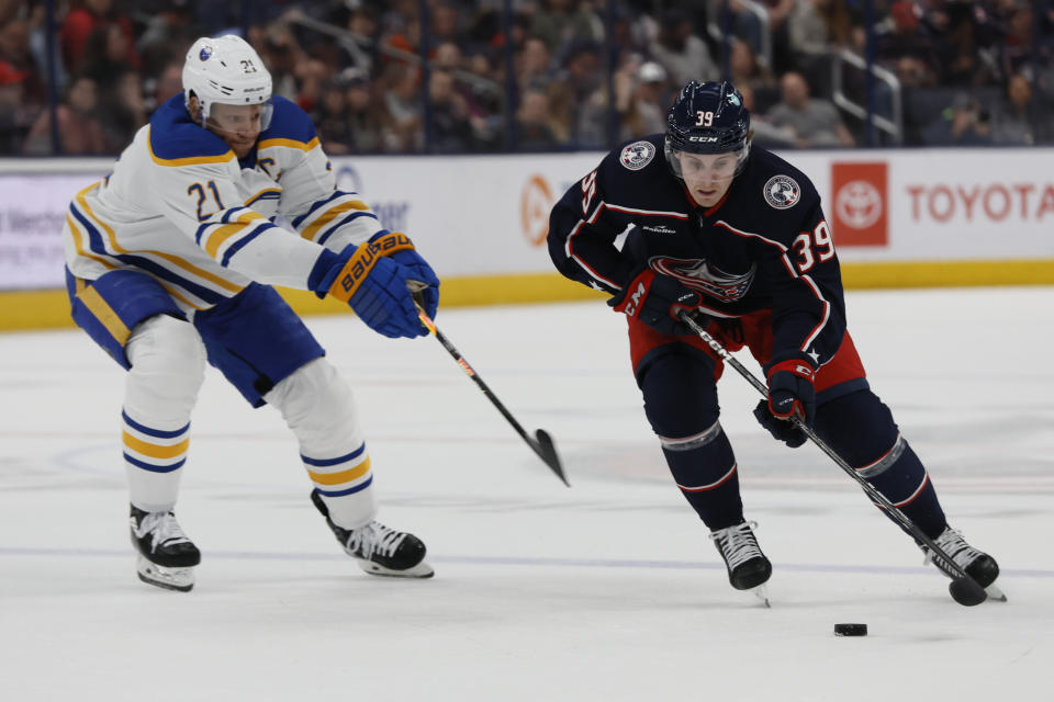 Columbus Blue Jackets' Tyler Angle, right, carries the puck across the blue line past Buffalo Sabres' Kyle Okposo during the second period of an NHL hockey game Friday, April 14, 2023, in Columbus, Ohio. (AP Photo/Jay LaPrete)