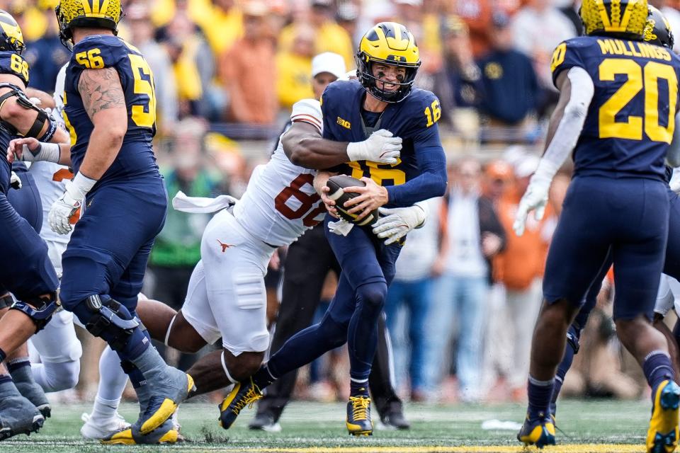 Michigan quarterback Davis Warren is sacked by Texas linebacker Barryn Sorrell during the second half at Michigan Stadium in Ann Arbor on Saturday.