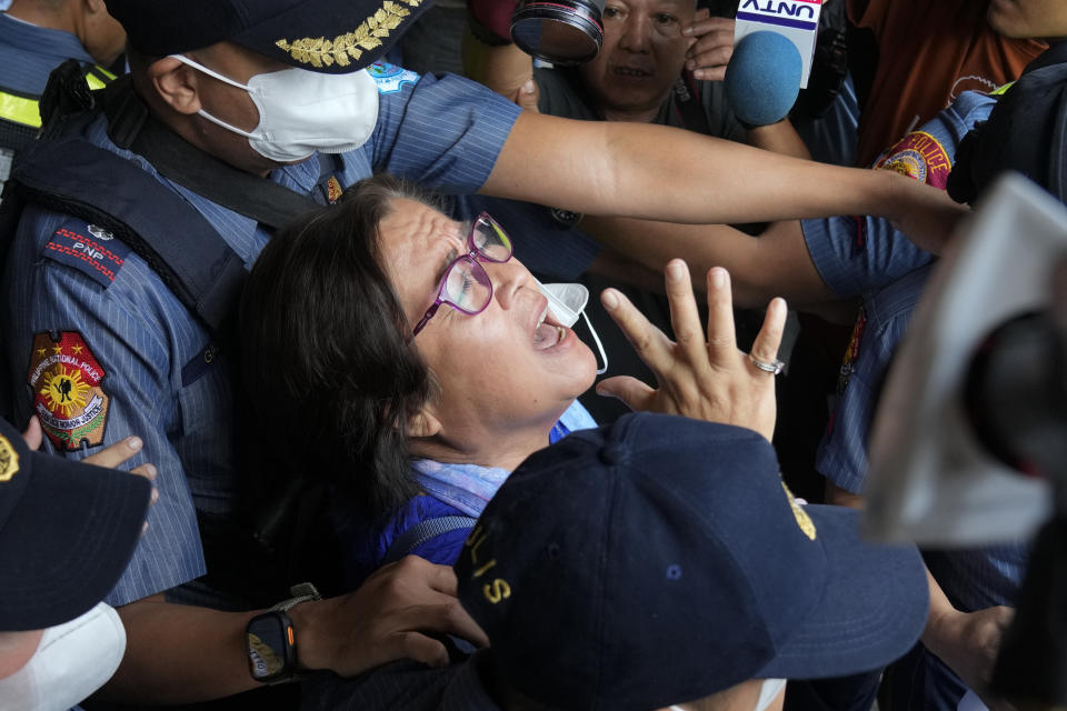 Detained former opposition Senator Leila de Lima, center, reacts as she goes out of the Muntinlupa trial court on Friday, May 12, 2023 in Muntinlupa, Philippines. De Lima was acquitted by the Muntinlupa court in one of her drug related charges she says were fabricated by former President Rodrigo Duterte and his officials in an attempt to muzzle her criticism of his deadly crackdown on illegal drugs. (AP Photo/Aaron Favila)