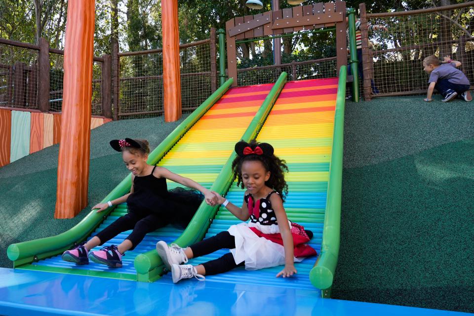 Mariah McIntyre, 8, and Myla McIntyre, 5, go down the colorful slide inside of Goofy’s How-To-Play Yard at Mickey’s Toontown at Disneyland.