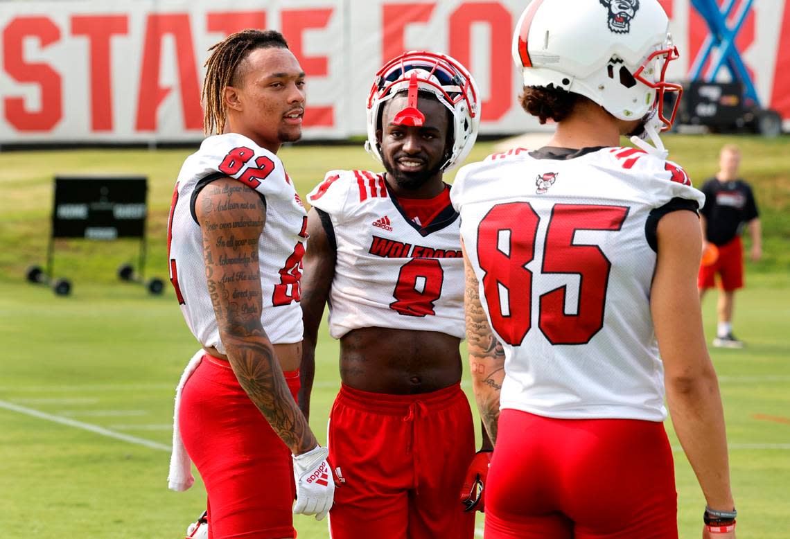 N.C. State wide receiver Terrell Timmons Jr. (82) talks with Julian Gray (8) and Anthony Smith (85) during the Wolfpack’s first fall practice in Raleigh, N.C., Wednesday, August 2, 2023. Ethan Hyman/ehyman@newsobserver.com