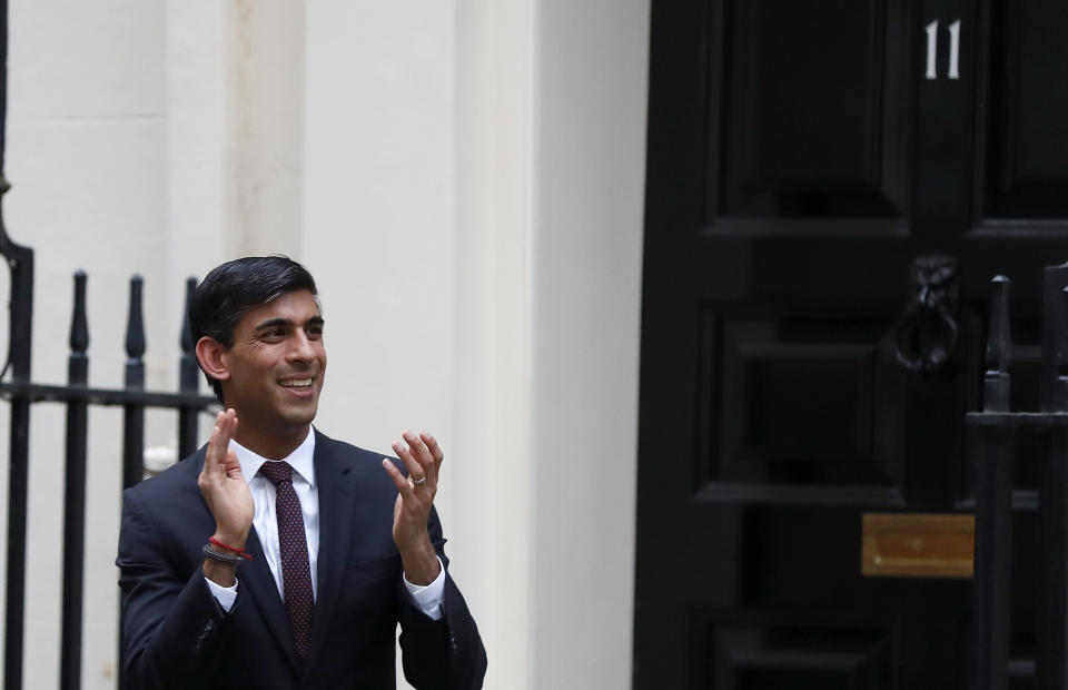 Britain's Chancellor of the Exchequer Rishi Sunak stands outside 11 Downing Street to join in the nationwide Clap for Carers to recognise and support National Health Service (NHS) workers and carers fighting the coronavirus pandemic, in London, Thursday, May 21, 2020. The COVID-19 coronavirus pandemic has prompted a public display of appreciation for care workers. The applause takes place across Britain every Thursday at 8pm local time to show appreciation for healthcare workers, emergency services, armed services, delivery drivers, shop workers, teachers, waste collectors, manufacturers, postal workers, cleaners, vets, engineers and all those helping people with coronavirus and keeping the country functioning while most people stayed at home in the lockdown. (AP Photo/Frank Augstein)