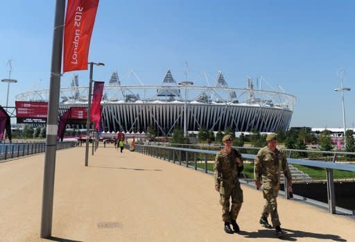 Soldiers walk to their post at the Olympic Stadium in London. Britain drafted another 1,200 troops Tuesday to plug a security gap at the London Olympics left by the failure of a private security firm to provide enough guards