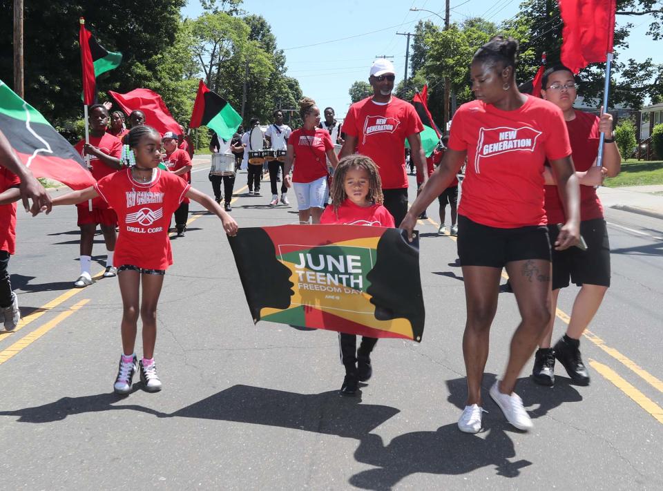 Members of the New Generation Drill Corps march in the West Akron Parade as they make their way to the Akron Juneteenth Festival on Sunday.