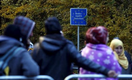 Migrants wait at the Austrian-German border in Achleiten, Austria, across from Passau, Germany October 29, 2015. REUTERS/Michaela Rehle