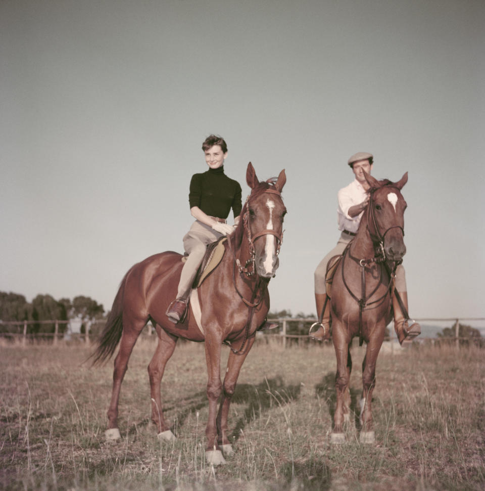 The actress, photographed with her first husband, Mel Ferrer, wears a turtleneck while riding a horse near Rome, 1955.