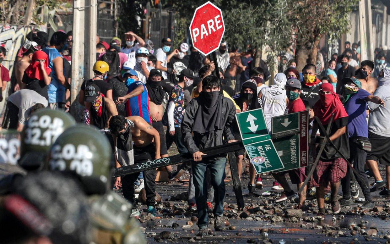 Demonstrators, some wearing protective face masks amid the new coronavirus pandemic, clash with the police - AP Photo/Esteban Felix