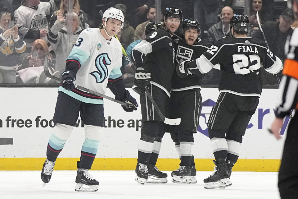 Los Angeles Kings right wing Adrian Kempe, second from left, celebrates his power-play goal with left wing Viktor Arvidsson, second from right, and left wing Kevin Fiala, right, as Seattle Kraken defenseman Will Borgen skates away during the first period of an NHL hockey game Wednesday, April 3, 2024, in Los Angeles. (AP Photo/Mark J. Terrill)